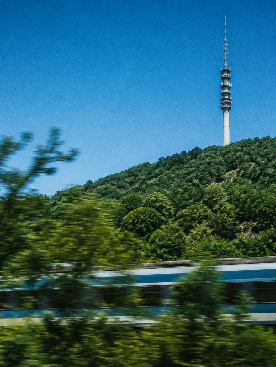 Communications mast above a green landscape